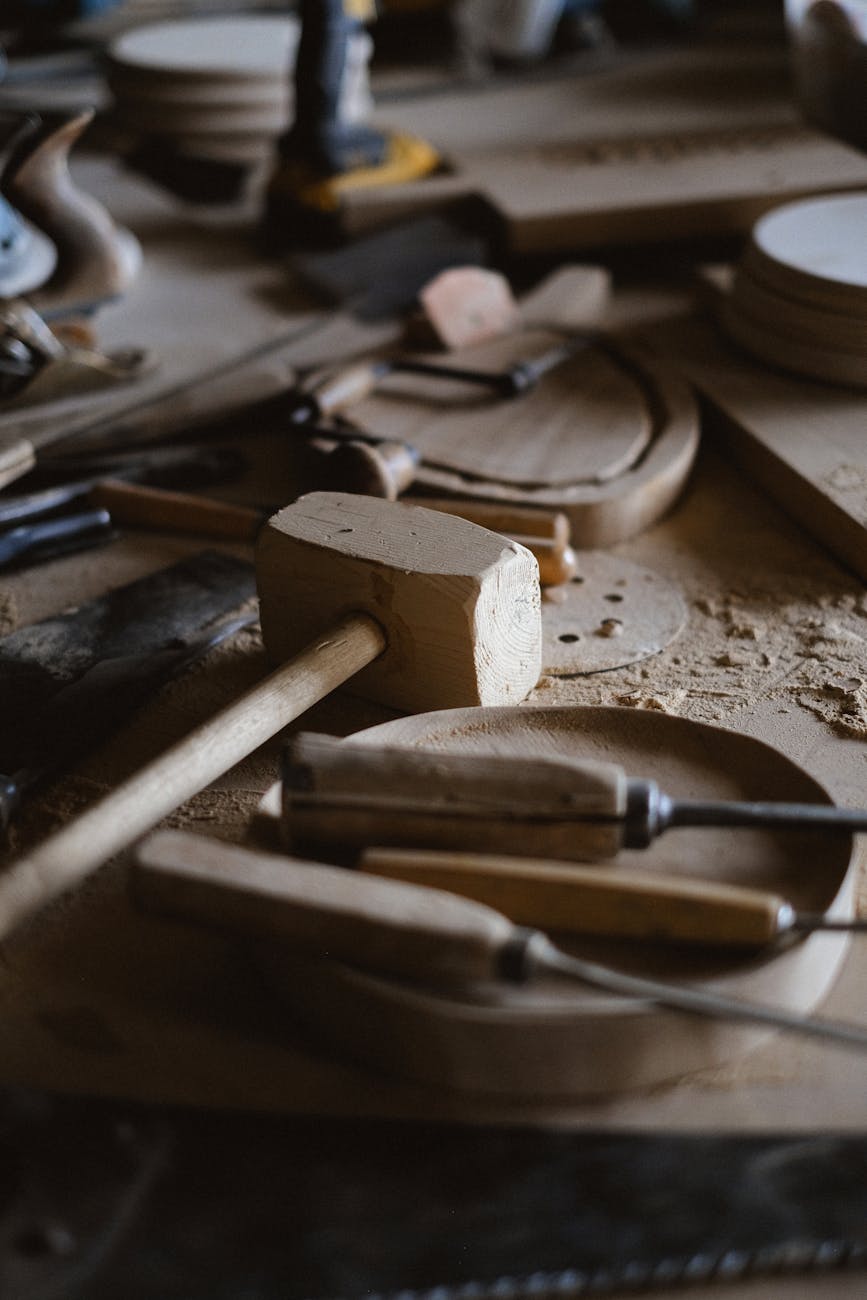 A variety of woodworking tools scattered on a workbench in a workshop setting.