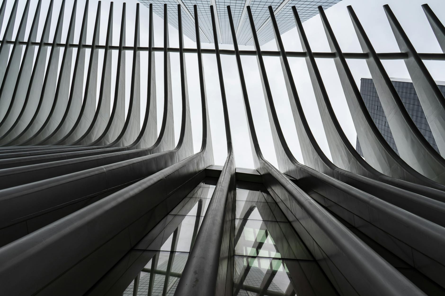 Low angle view of a futuristic building's steel and glass facade with a modern design.