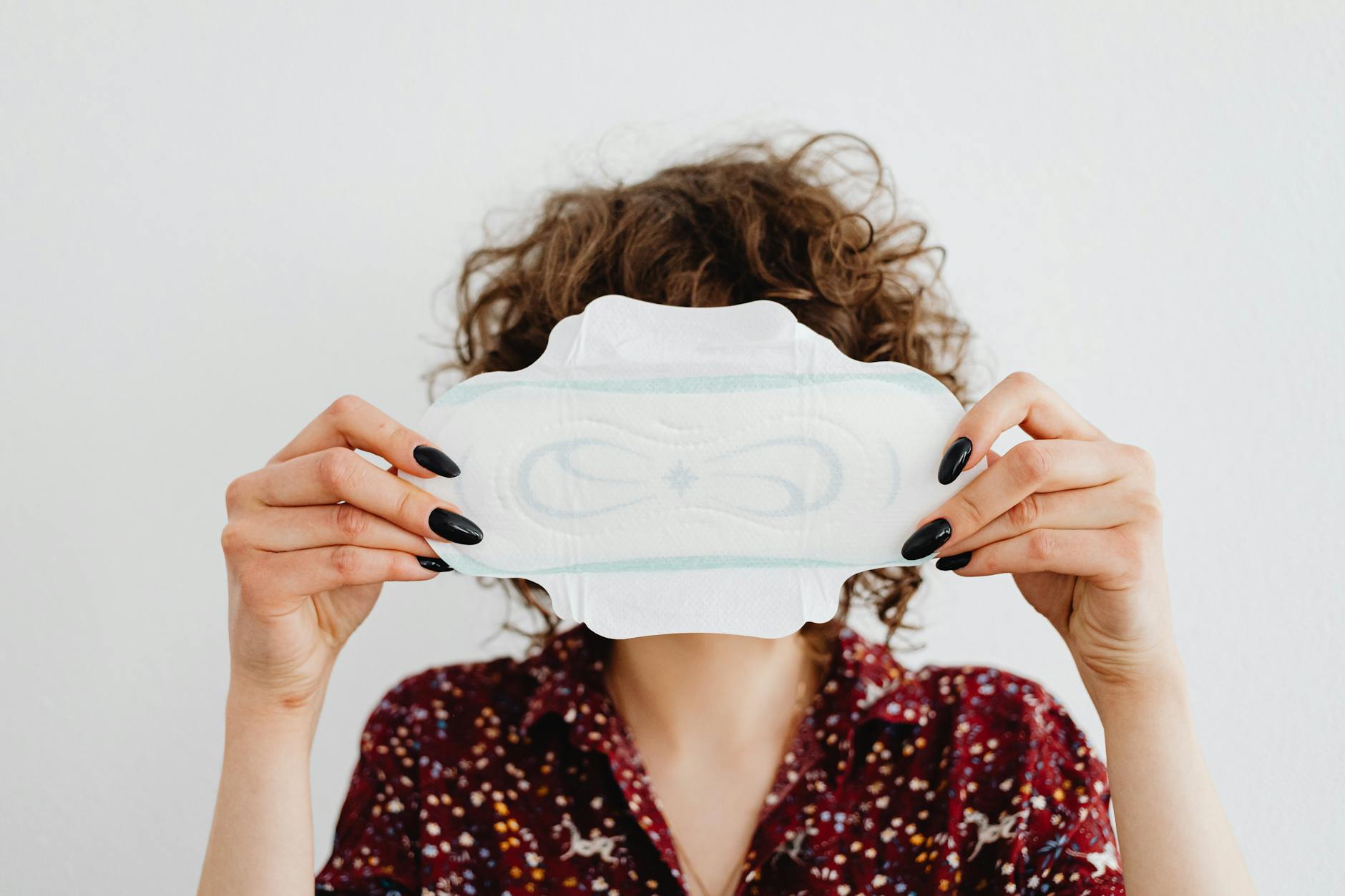 A woman holding a sanitary pad, highlighting menstrual health and hygiene issues.