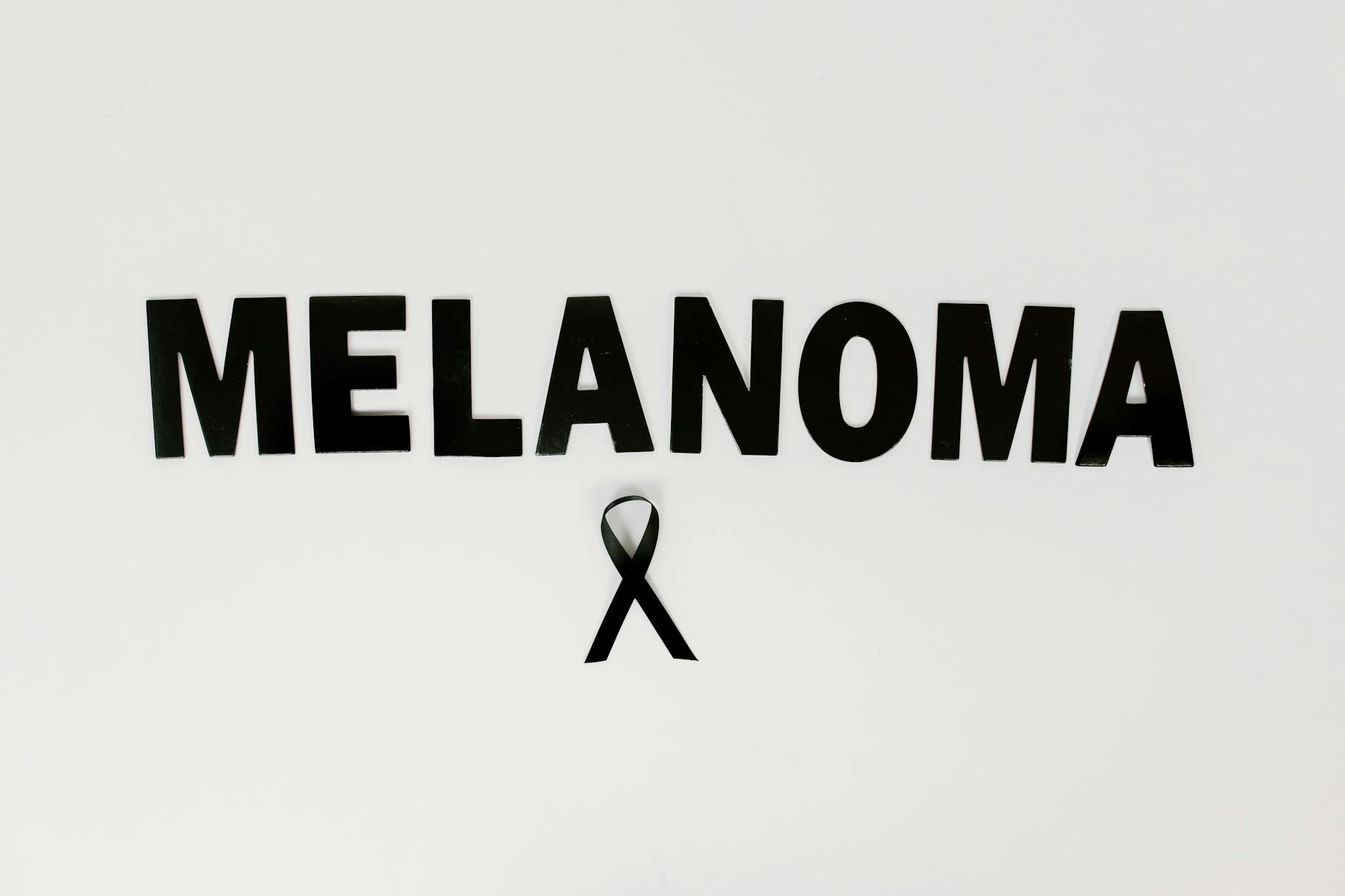 Melanoma awareness text with black ribbon symbolizing skin cancer support.