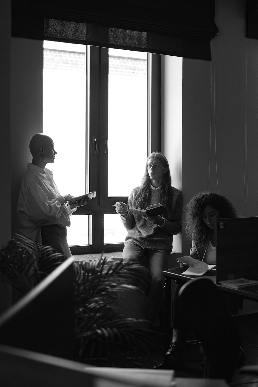 Black and white of man and women gathering together for meeting and business discussion in modern office