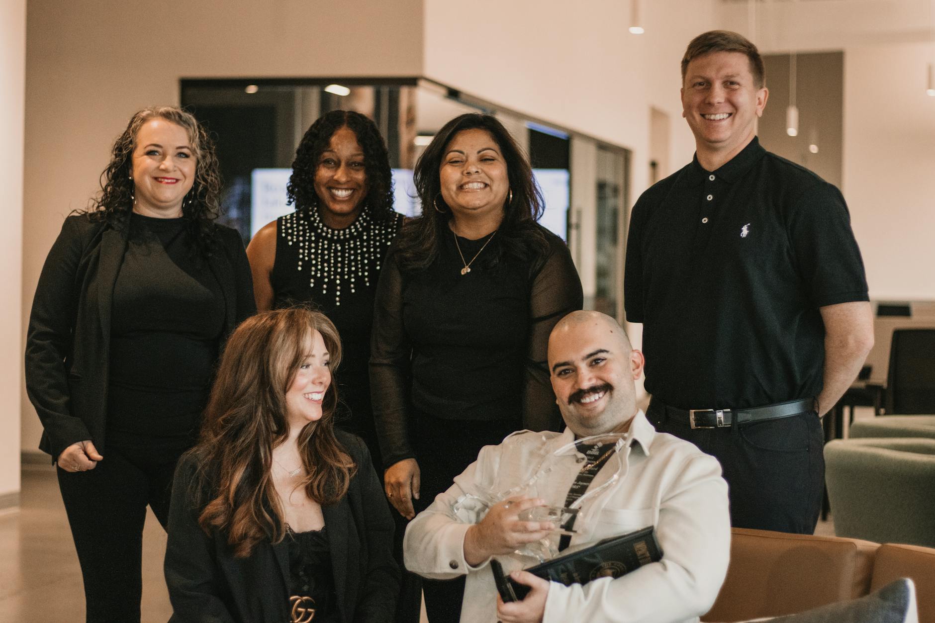 Team of real estate agents posing confidently in modern office.