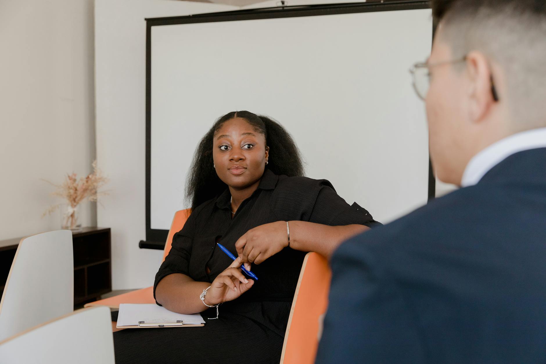 Two colleagues engage in a corporate discussion in an office setting.