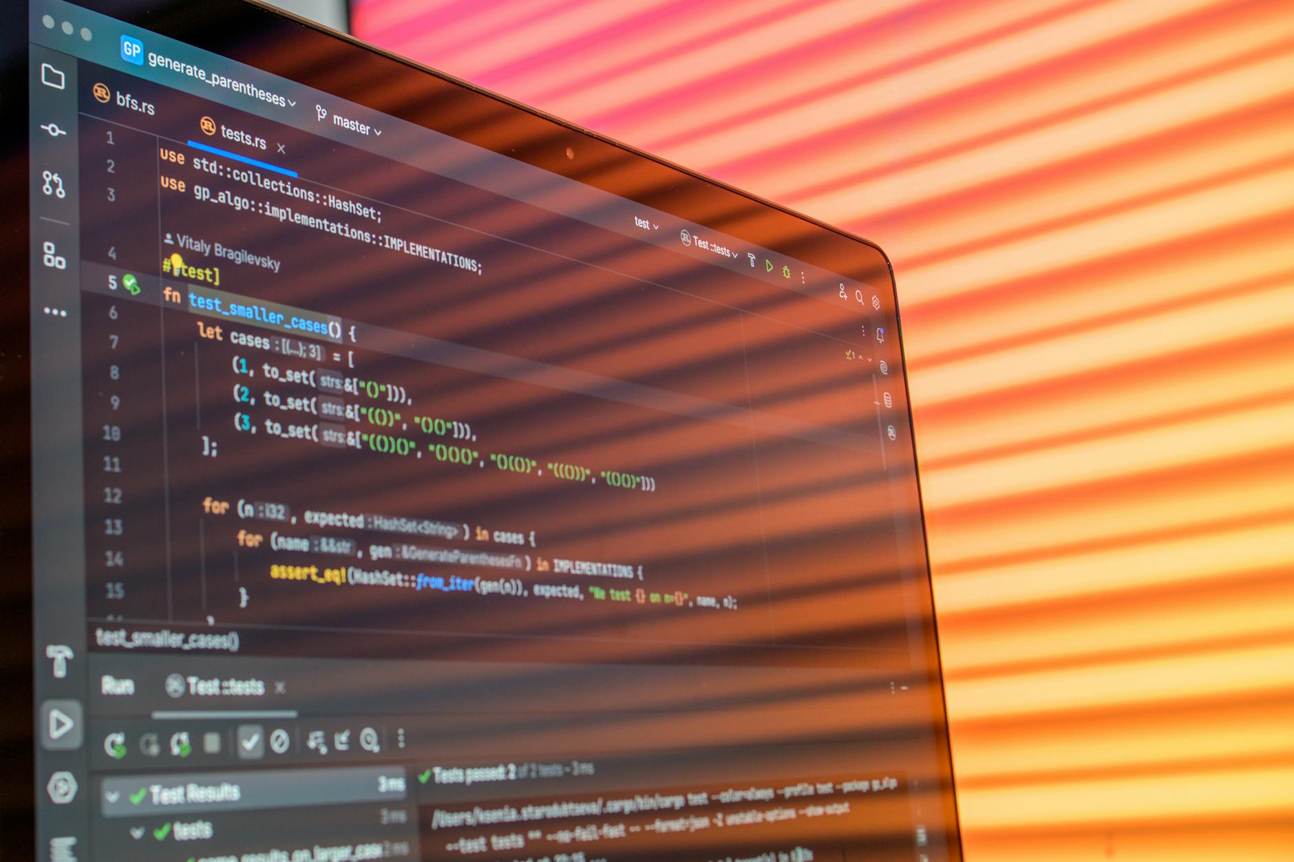 Colorful abstract reflection on screen showing programming code in development environment.