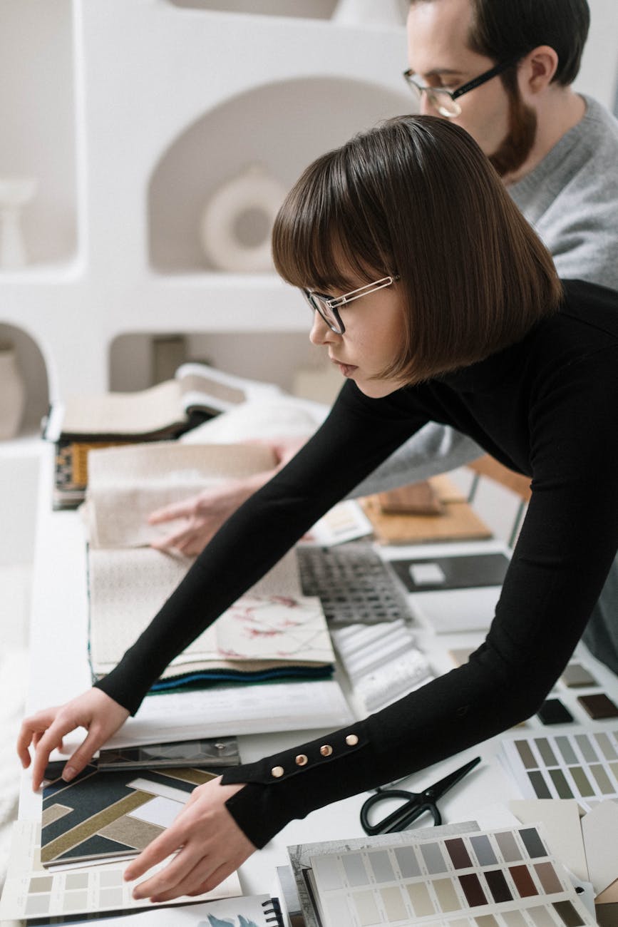 Two individuals in an office carefully selecting design patterns, showcasing teamwork and creativity.