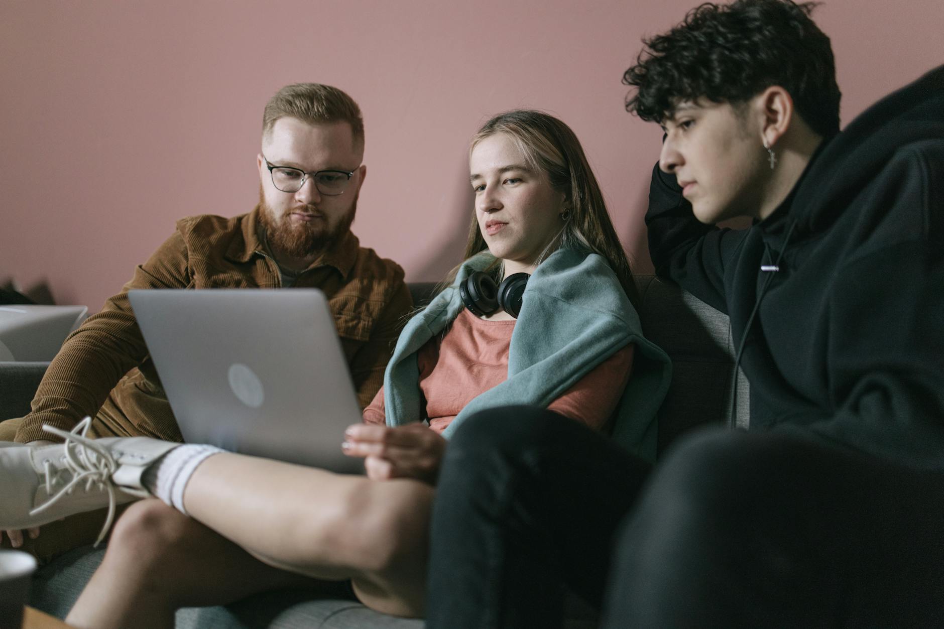 Young diverse team collaborates on a project using a laptop in an office setting.