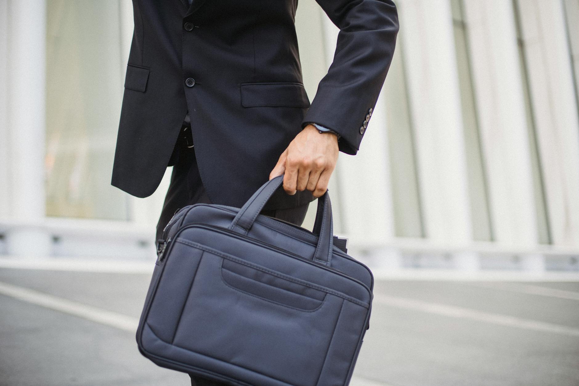 Close-up of a businessman carrying a briefcase in urban environment.