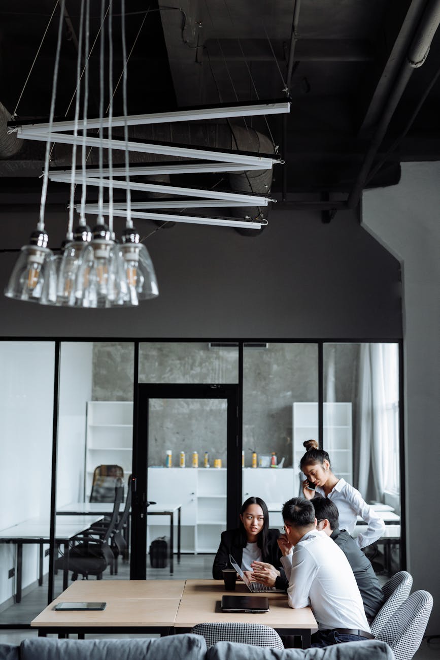 Business professionals engaged in a collaborative meeting in a stylish, modern office setting.