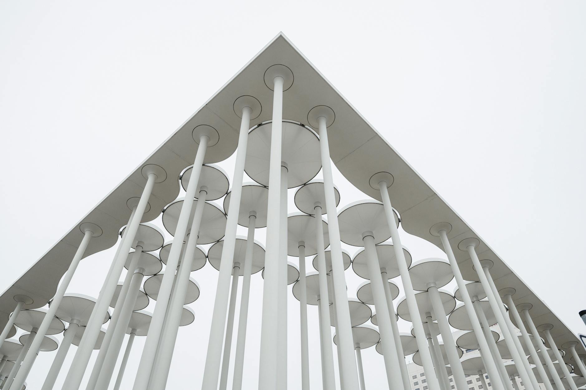 Abstract view of modern minimalist architectural structure with overcast sky.
