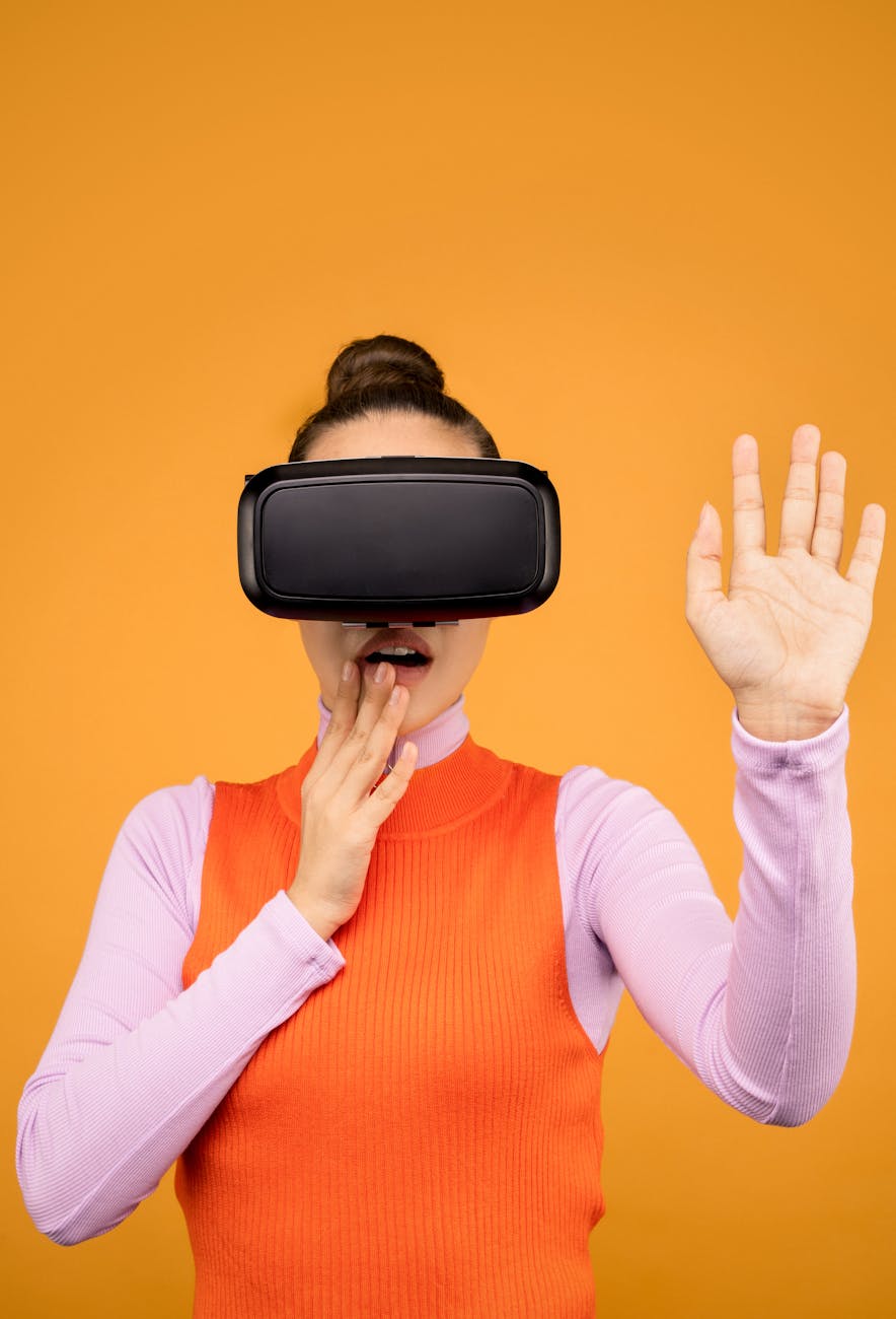 Woman enjoying a virtual reality experience wearing a VR headset against a vibrant orange background.