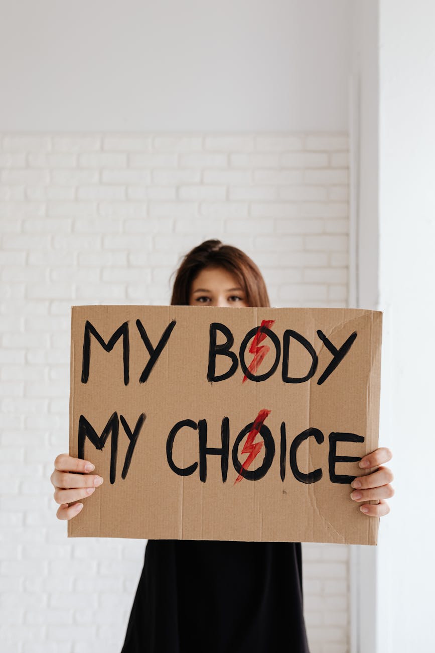 Woman holding 'My Body My Choice' sign, advocating for women's rights.
