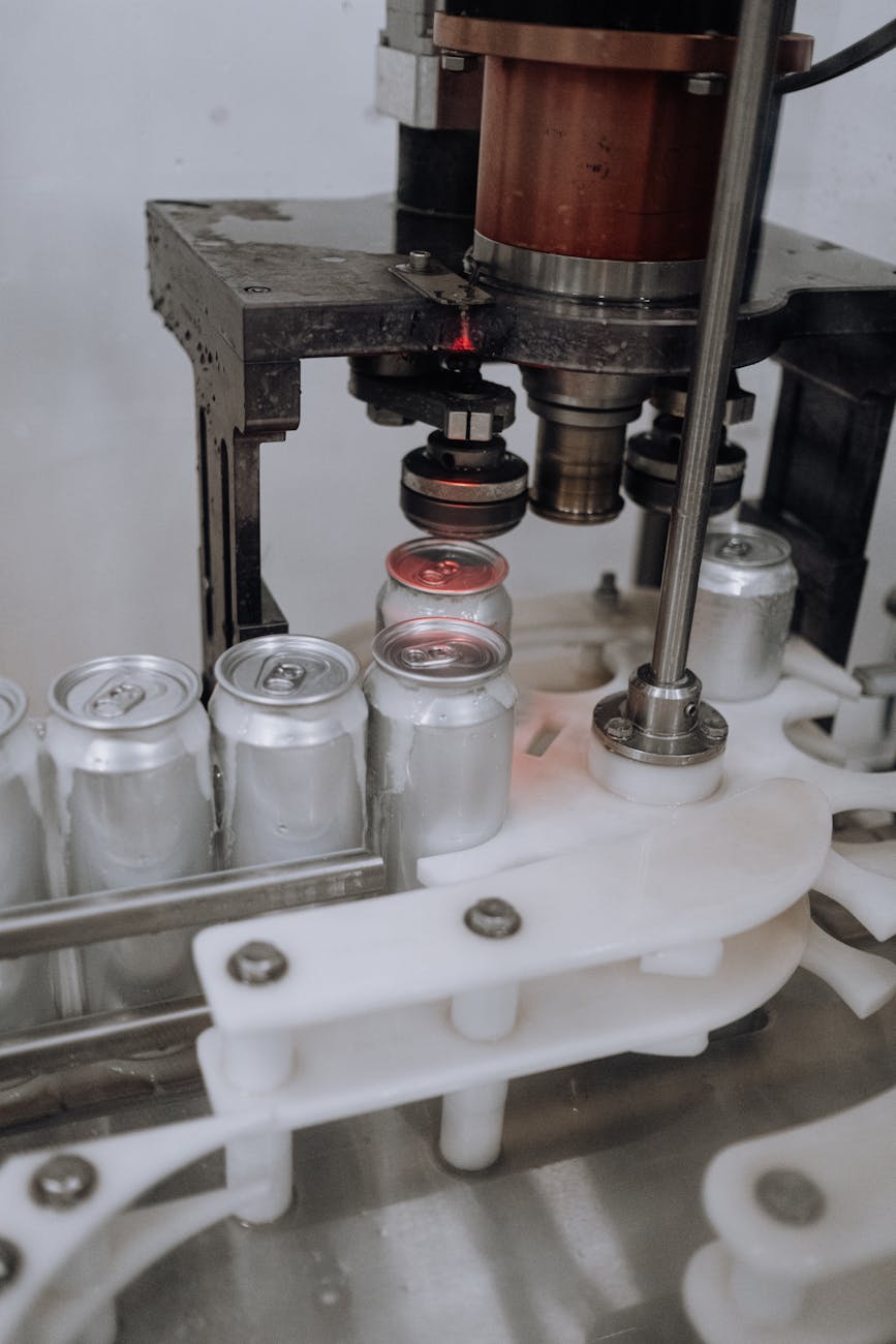 Close-up of beverage cans on an automated assembly line in a factory.