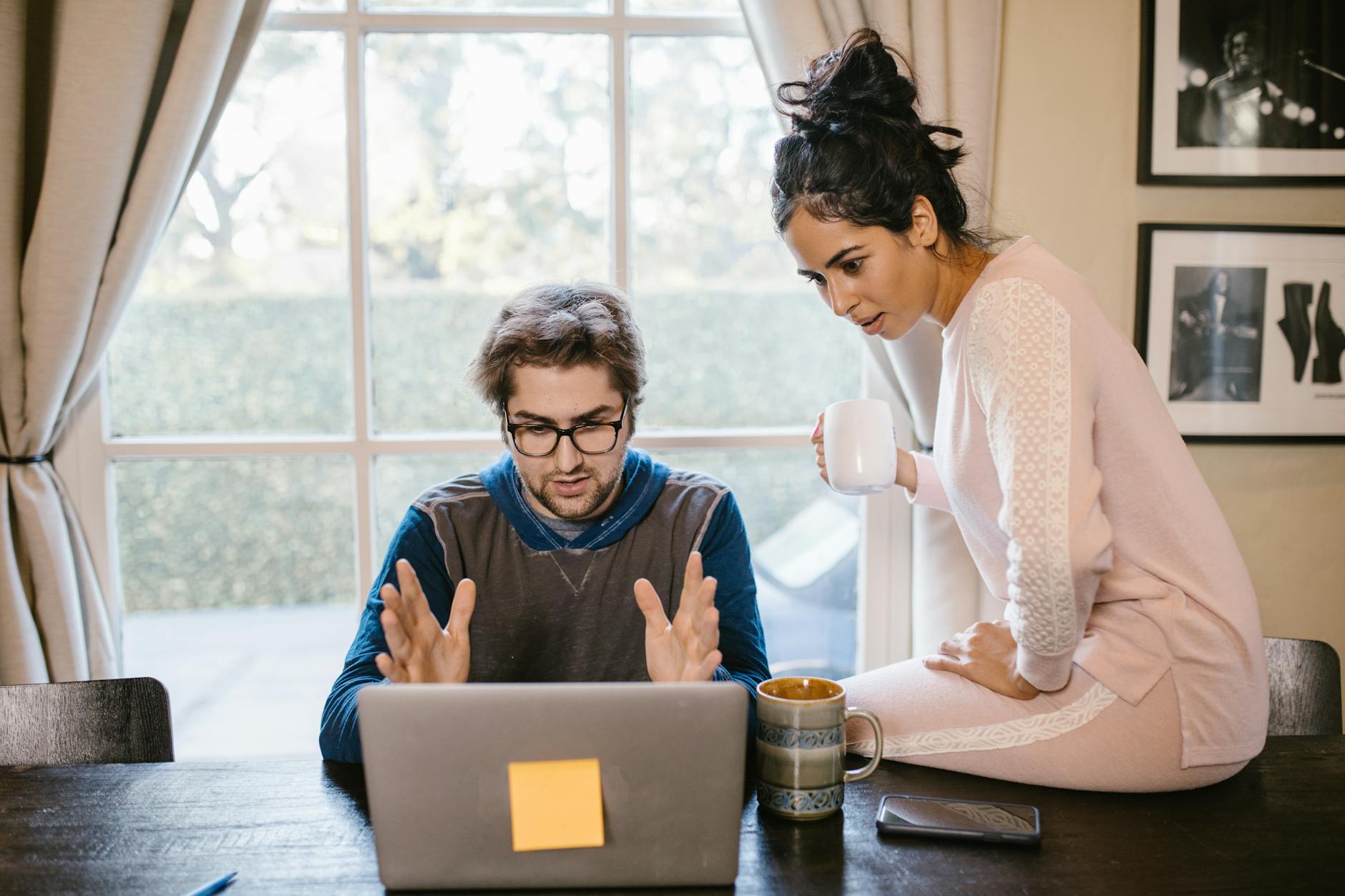A man and woman working together on a laptop at a wooden table with warm, relaxing ambiance.